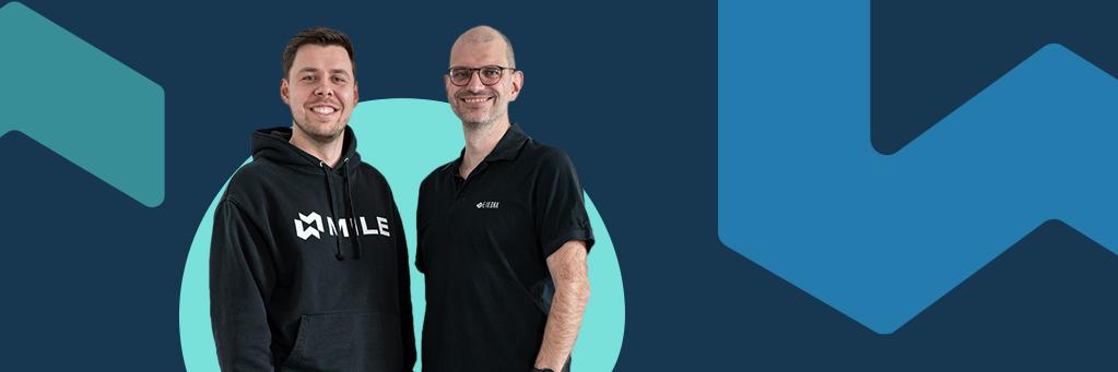 Ein blauer Hintergrund, auf dem Steffen Hauptmann und Stefan Seufert im Vordergrund abgebildet sind.