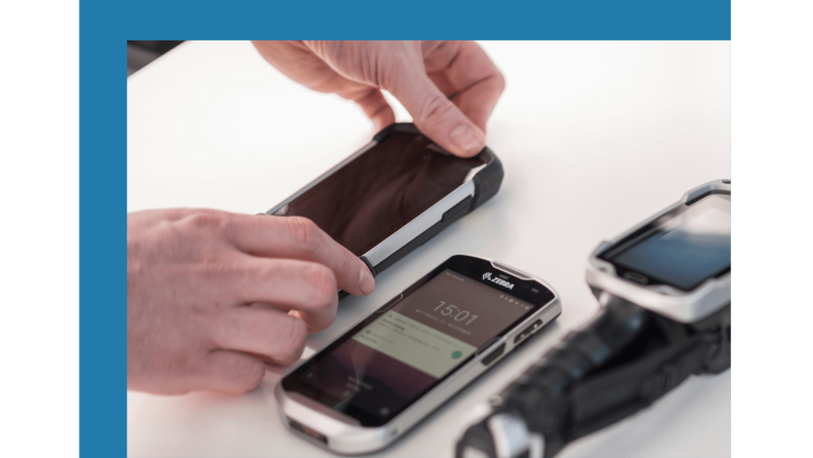 Drei Mobile Endgeräte liegen auf einem Tisch.