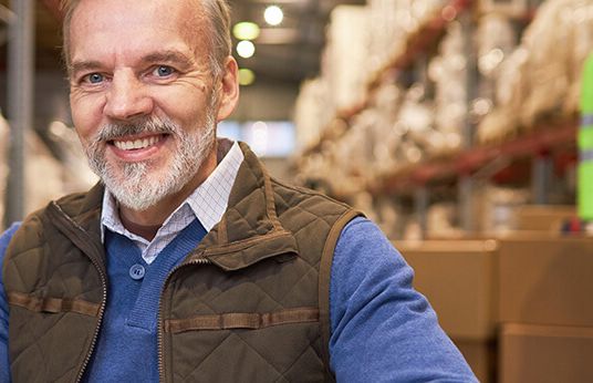 A logistics employee is pleased with the professional WLAN planning in the warehouse.