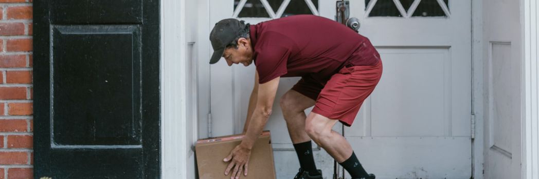 Deliverer places a parcel at the entrance of the house with the help of a suitable TMS