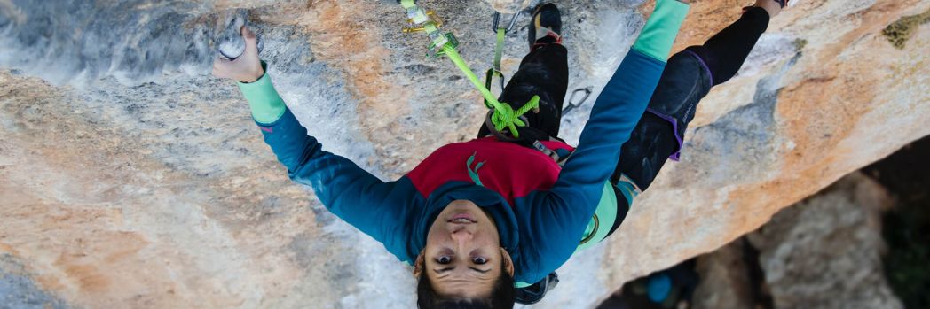 Woman climbing a mountain which stands for hacking in the form of a penetration test which evaluates security vulnerabilities