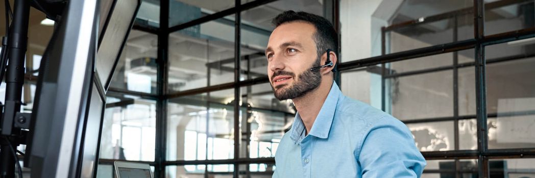 Mann sitzt an seinem Schreibtisch und arbeitet an digitalisierten Speditionsaufträgen im Order Management