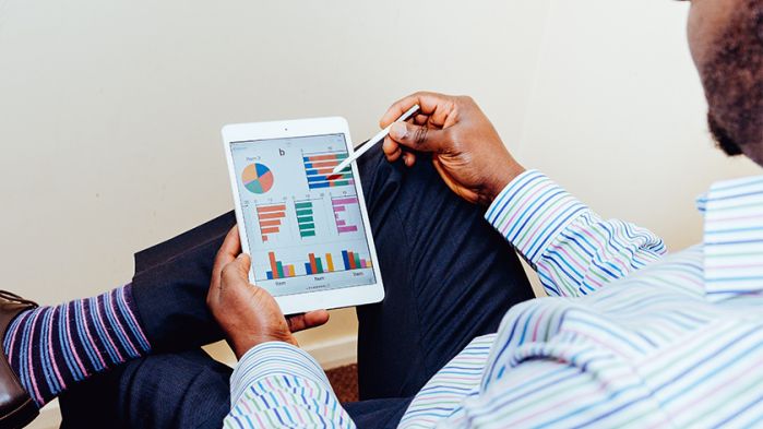 Man in striped shirt editing diagrams on his ipad