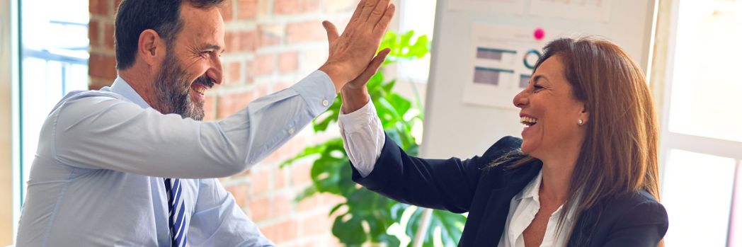 Colleagues high-five each other after successful electronic data integration.
