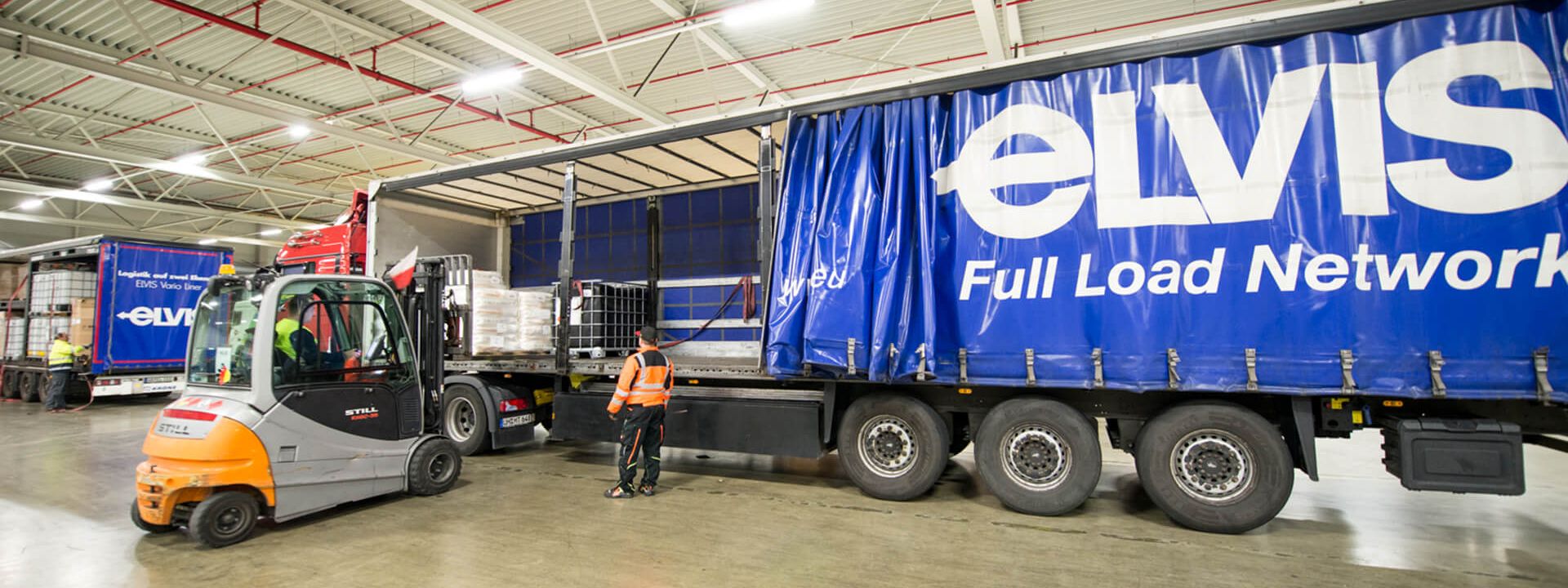 An ELVIS AG truck is loaded by a forklift.