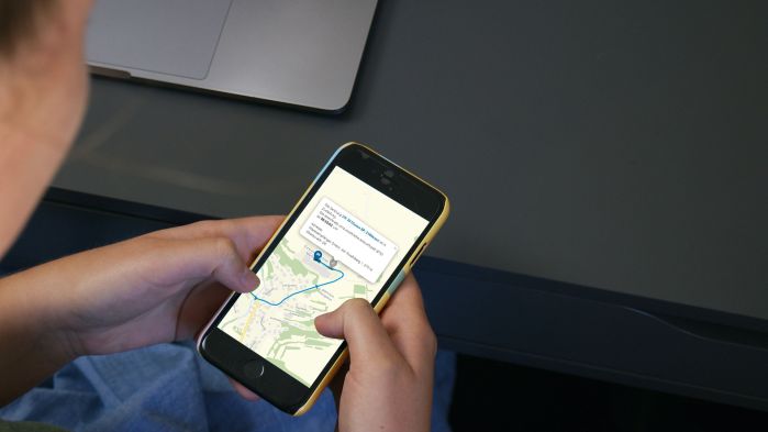 Mann schaut sich Route im Routenplaner auf seinem Handy an