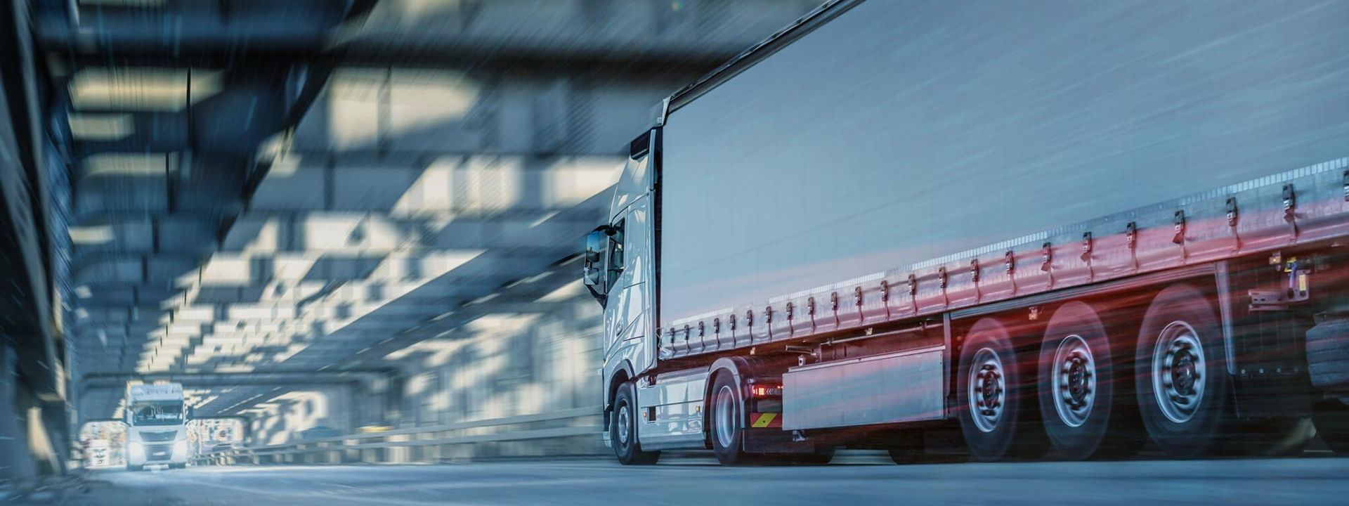 Zwei LKWS fahren ine einem Tunnel aufeinander zu.