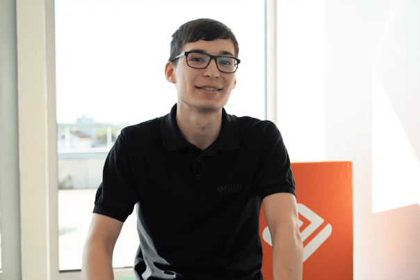 Ein Auszubildender in einem Büro, der ein T-Shirt trägt.