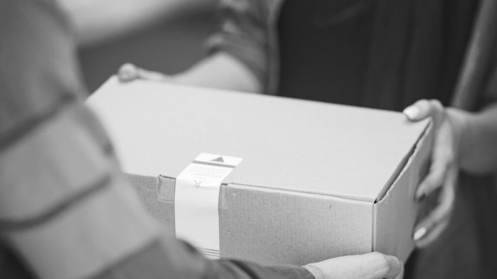 Man hands over package to a woman