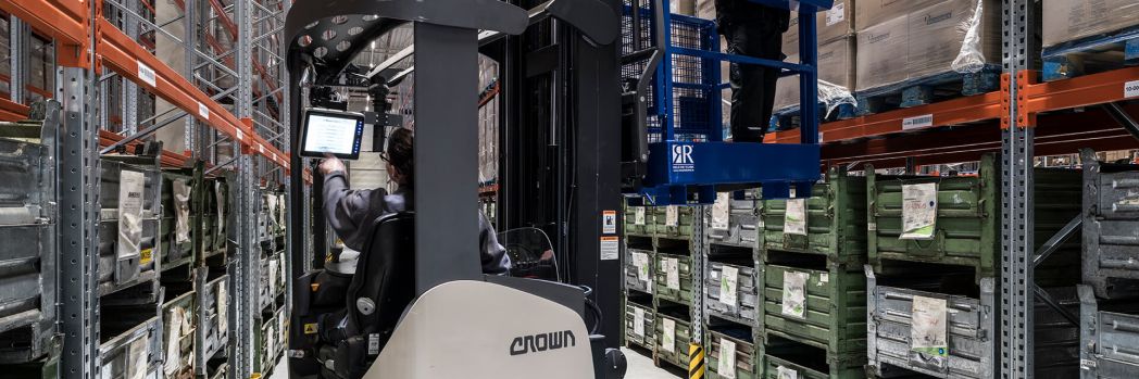 Mitarbeiter im Lager erfasst Daten auf seinem mobilen Gerät im Stapler.