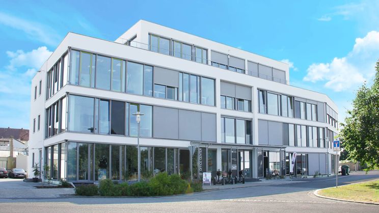 White office building with large window front.