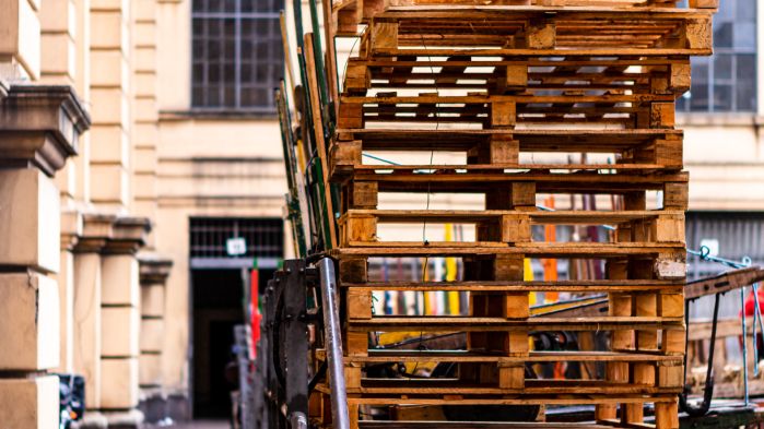 Many pallets stacked on top of each other in the yard of a forwarding company