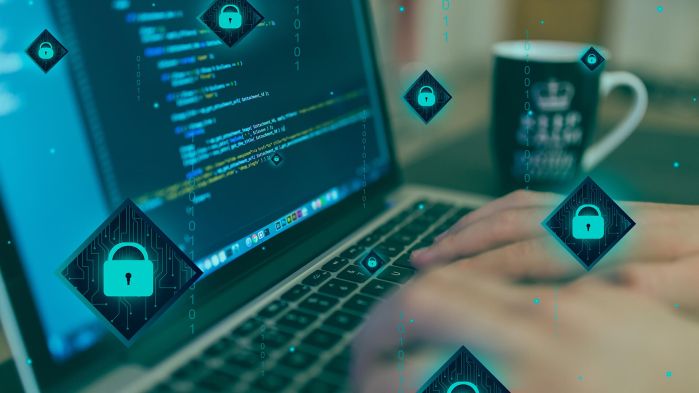 Hacker an Computer welcher für hohen Wert der IT-Sicherheit in Unternehmen stehen soll
