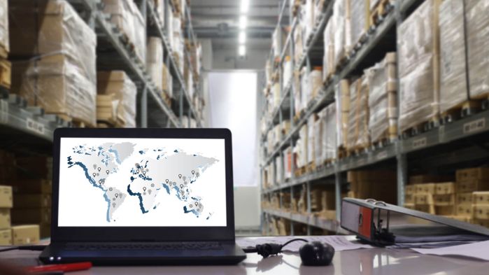 Laptop with map on the screen standing on the desk in a warehouse