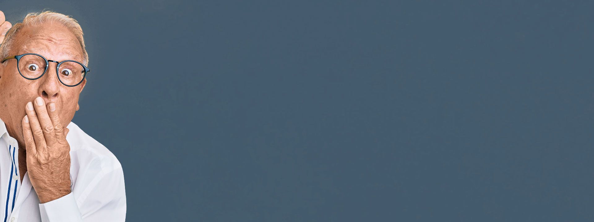 Ein Mann mit Brille schlägt sich entsetzt die Hand vor den Mund,