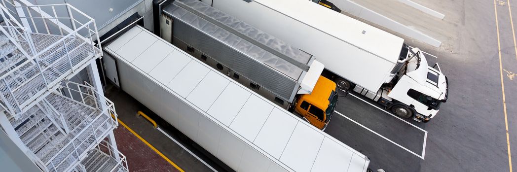 Vier LKW stehen an der Rampe einer Spedition und werden dank Zeitfenstermanagement pünktlich beladen