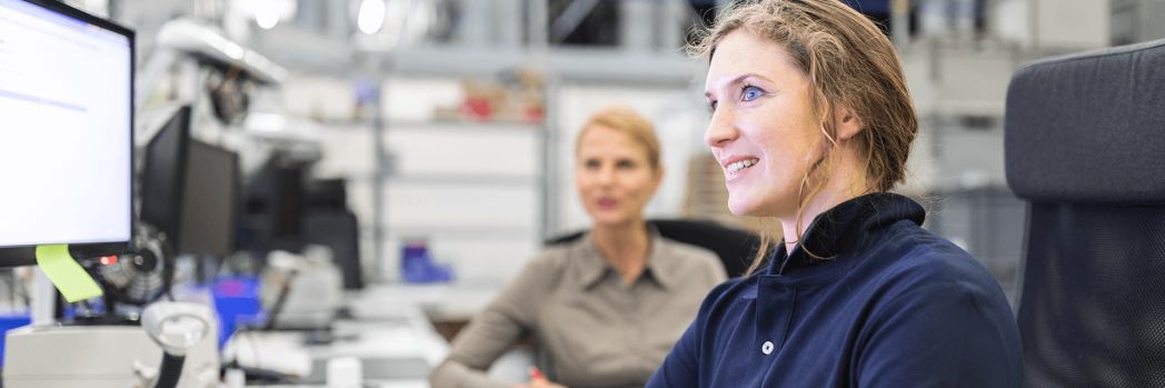 Disponentin sitzt am Arbeitsplatz für Logistikplanung und führt diese gemeinsam mit ihrer Kollegin durch