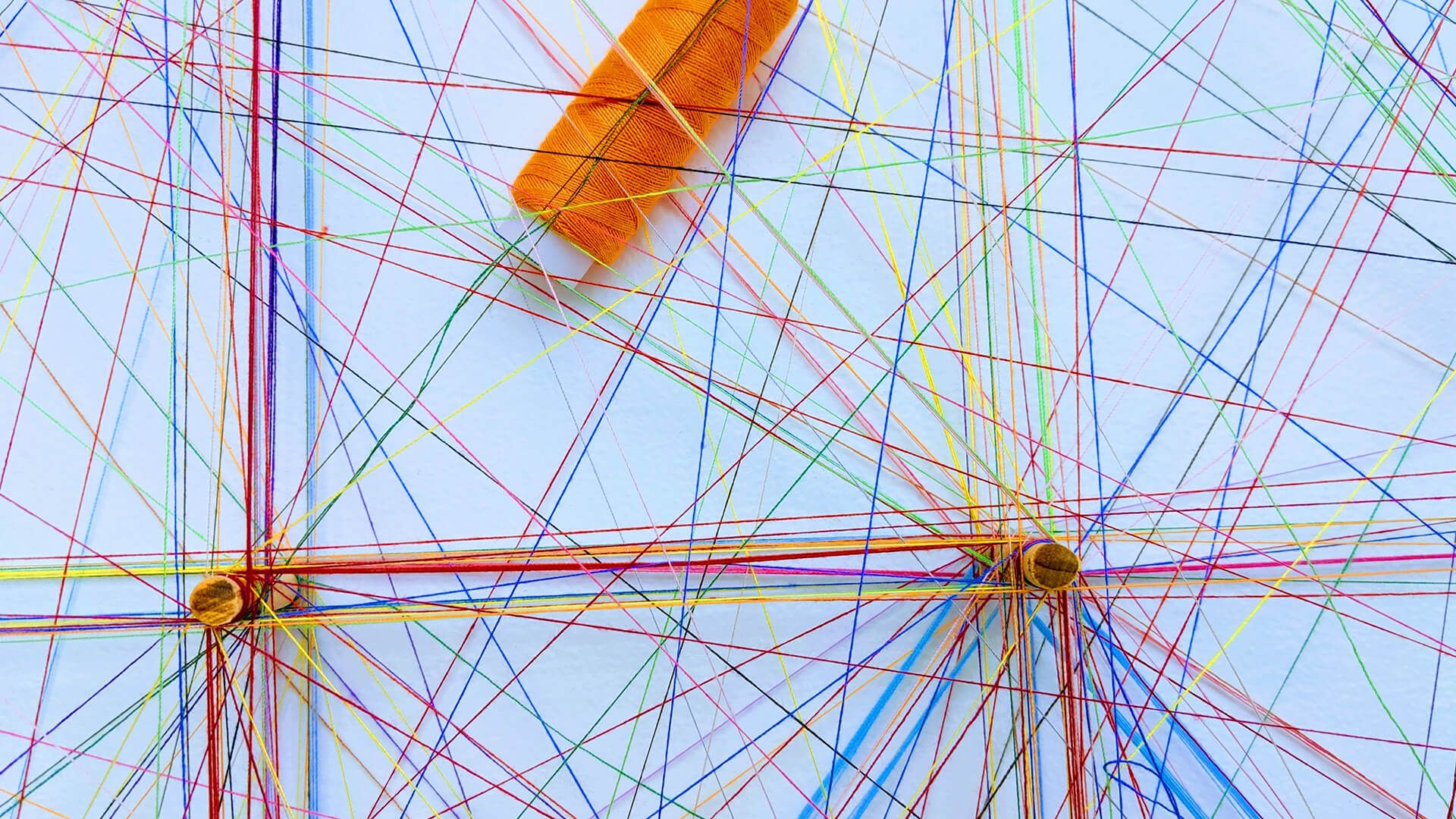 Many colorful threads, which stand for the connections within a logistics chain.