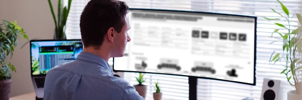 Man sits at his desk and looks at the monitor of his computer