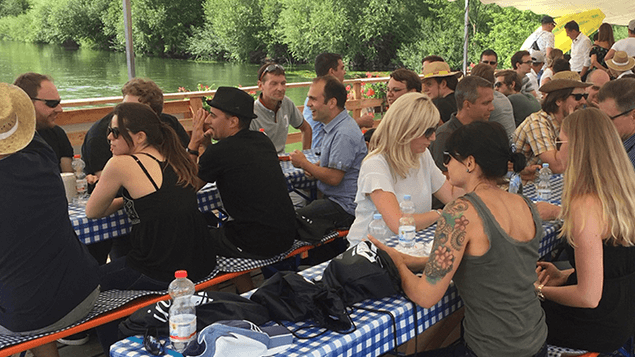 Mehrere Personen sitzen während einer Veranstaltung an einem Tisch.