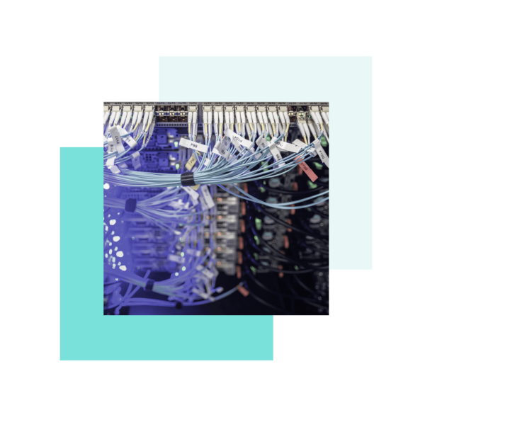 Techniker steht in Lagerhalle und führt Netzwerkverkabelung durch.