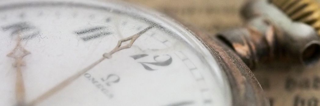 Taschenuhr liegt auf einem historischen Buch