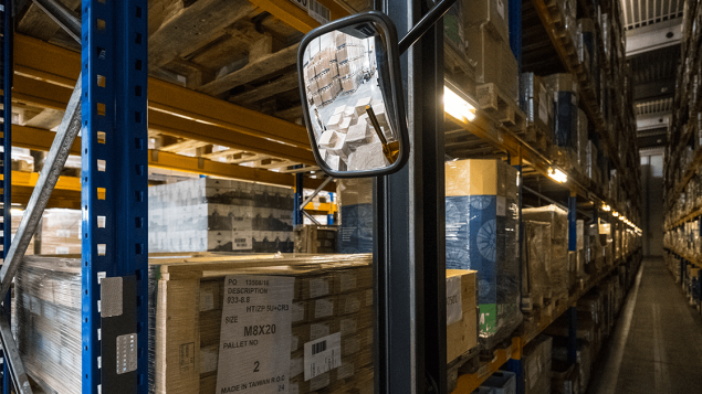 A warehouse and a mirror of a forklift truck.