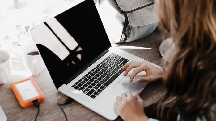 Woman works on her laptop and changes her email distribution list to be DSGVO compliant to protect herself from cyber attacks