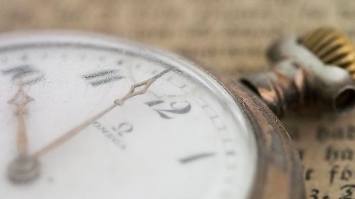 Taschenuhr liegt auf einem historischen Buch