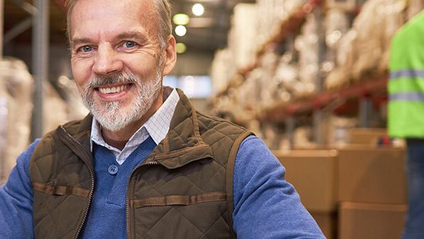 Ein Logistikmitarbeiter freut sich über die professionelle WLAN-Planung im Lager.