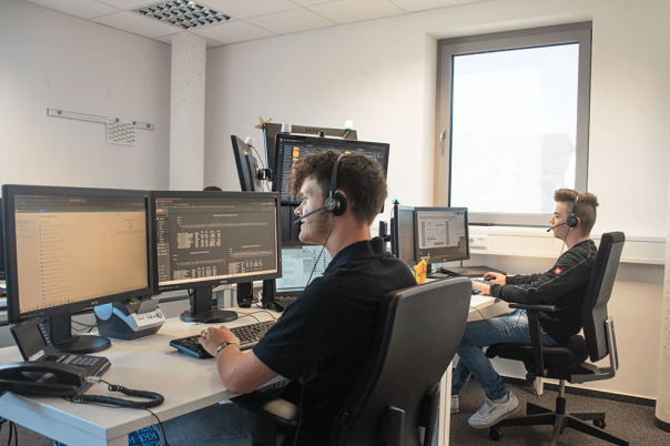 Zwei Azubis arbeiten an Computern in einem Büro.