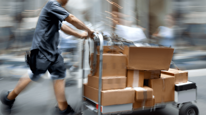 Delivery person with parcel trolley which should stand for multi-channel logistics