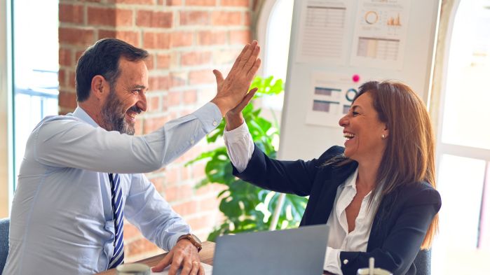 Kollegen geben sich High-Five nach erfolgreicher elektronischer Datenintegration.