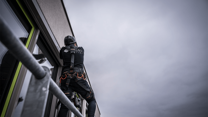 Industrial WLAN is installed on the façade of a building by an EIKONA Logistics employee.