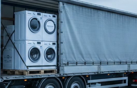 A truck on the highway transports washing machines, showcasing efficient line optimization in logistics.