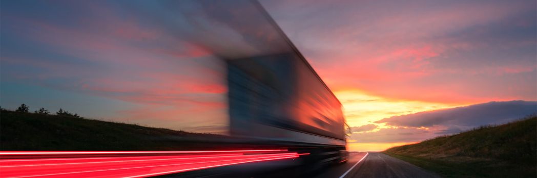 Truck whizzes by on a highway, representing the efficiency gains of Business Process as a Service