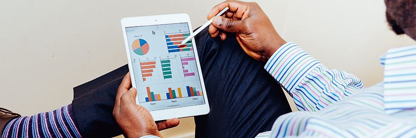 Man in striped shirt editing diagrams on his ipad