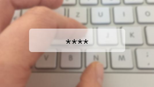 Mitarbeiter gibt verschlüsseltes Passwort in Tastatur mit Hilfe von Passwort-Tool ein.