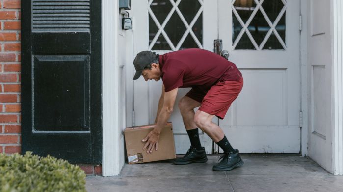Deliverer places a parcel at the entrance of the house with the help of a suitable TMS