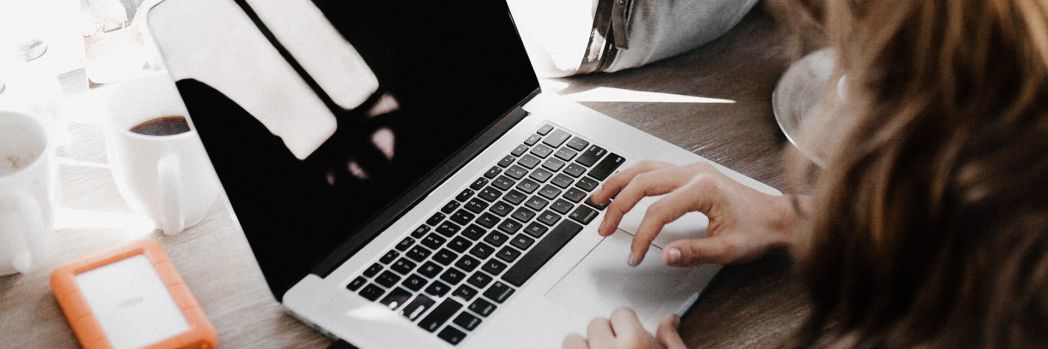 Woman works on her laptop and changes her email distribution list to be DSGVO compliant to protect herself from cyber attacks