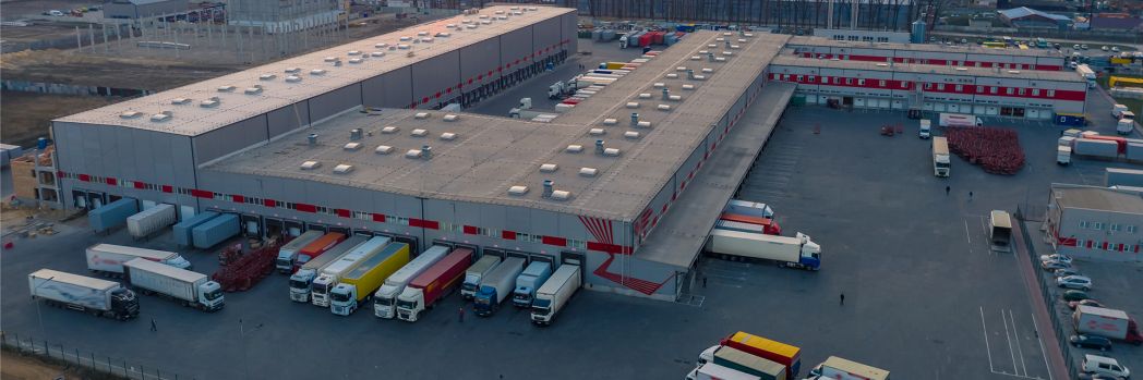 In the yard of a forwarding agency, trucks are being loaded.