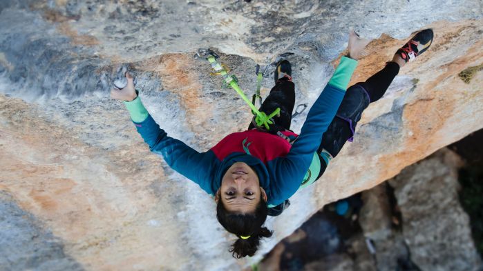 Woman climbing a mountain which stands for hacking in the form of a penetration test which evaluates security vulnerabilities