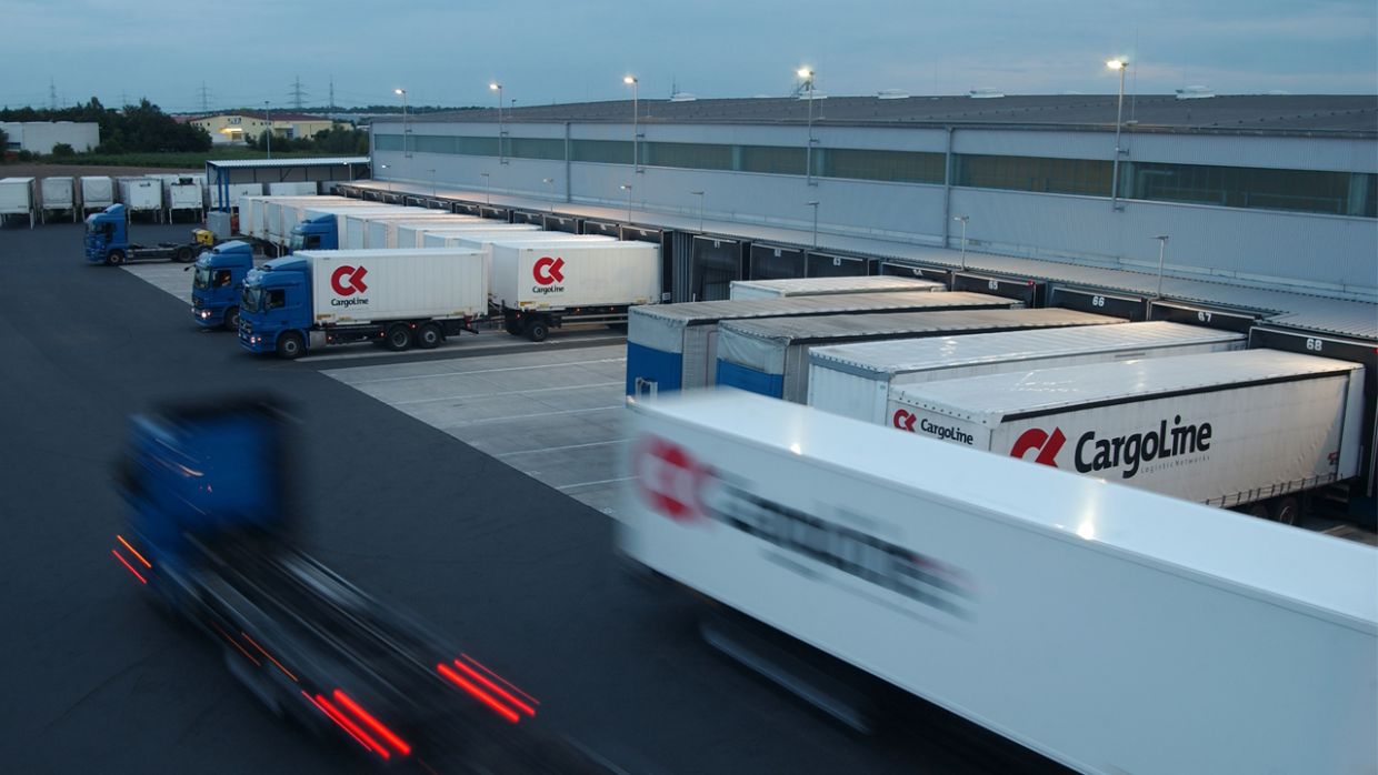 IT Plattform von EIKONA Logistics vereinfacht Datenaustausch bei CargoLine CargoLine LKWS an Rampen in einem Ladehof.