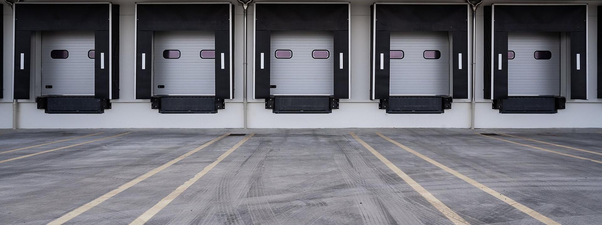Five white loading ramps of a warehouse.