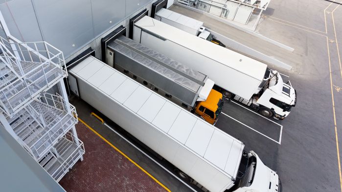 Vier LKW stehen an der Rampe einer Spedition und werden dank Zeitfenstermanagement pünktlich beladen