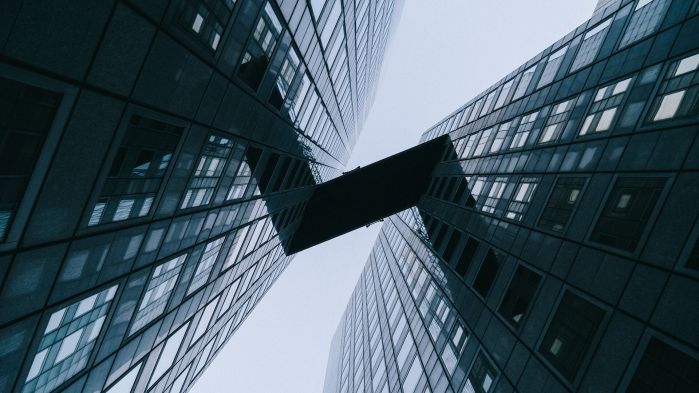 Two glass skyscrapers that are connected to each other