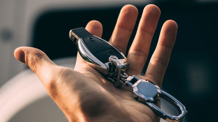 Hand welche Autoschlüssel hält was für eine DSGVO-konforme Führerscheinkontrolle stehen soll