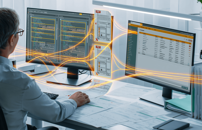 Ein Mitarbeiter nutzt zwei Monitore für effizientes KI-gestütztes Dokumentenmanagement am Schreibtisch.