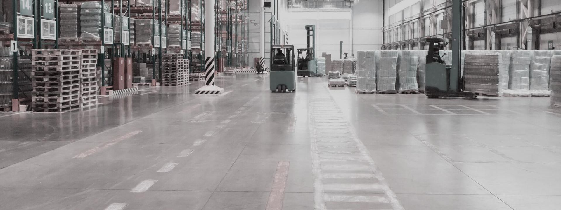 Warehouse with goods and forklift trucks.