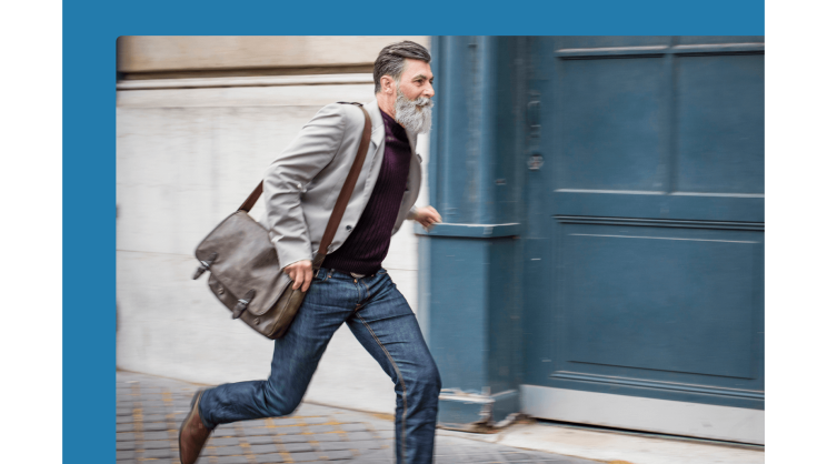 A man with a beard walks on the pavement in front of a blue door.